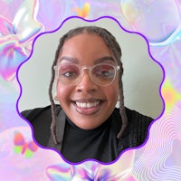 a black woman with glasses smiling in front of a purple background